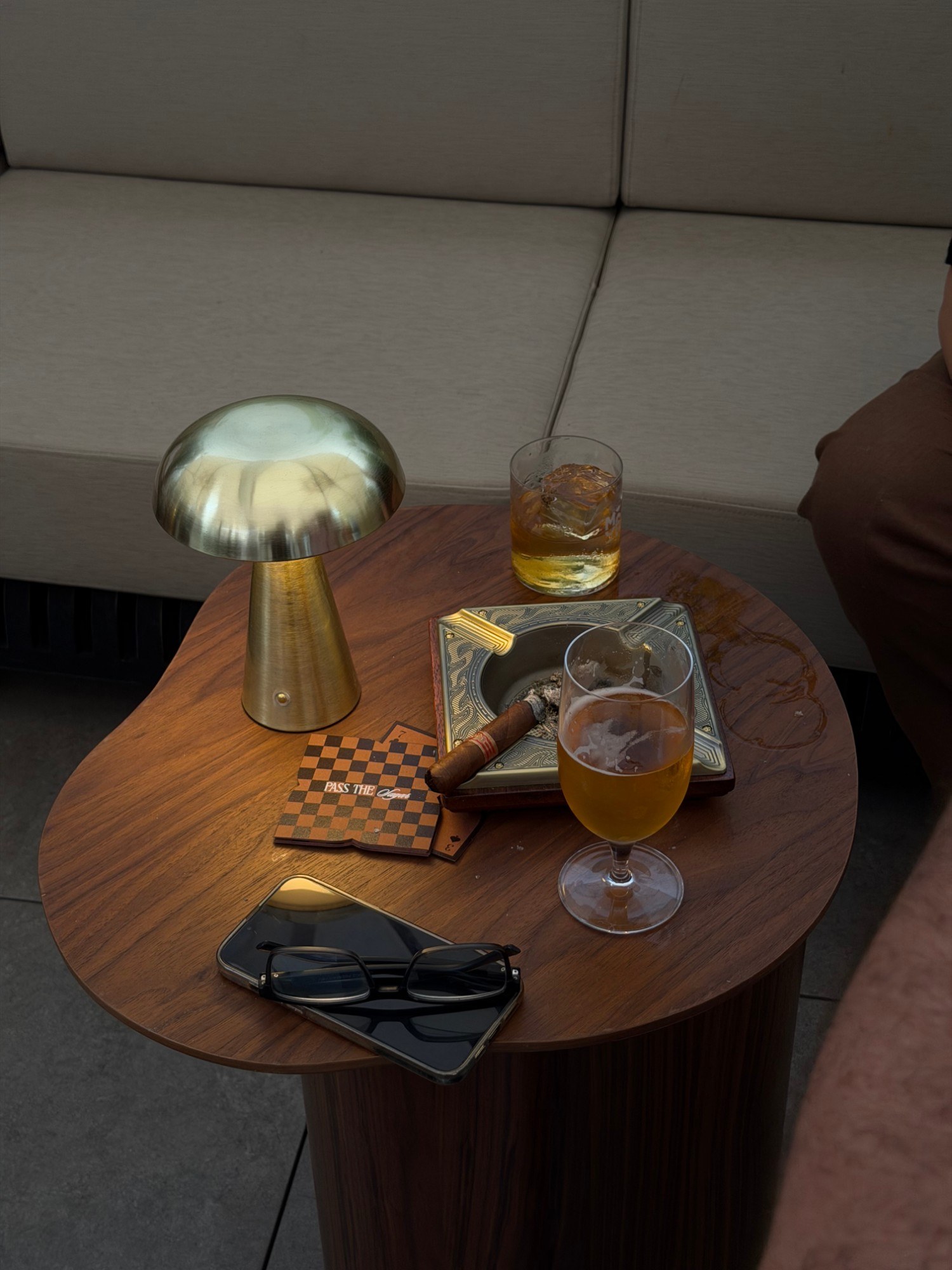 Lounge scene with brass lamp, ashtray and drinks